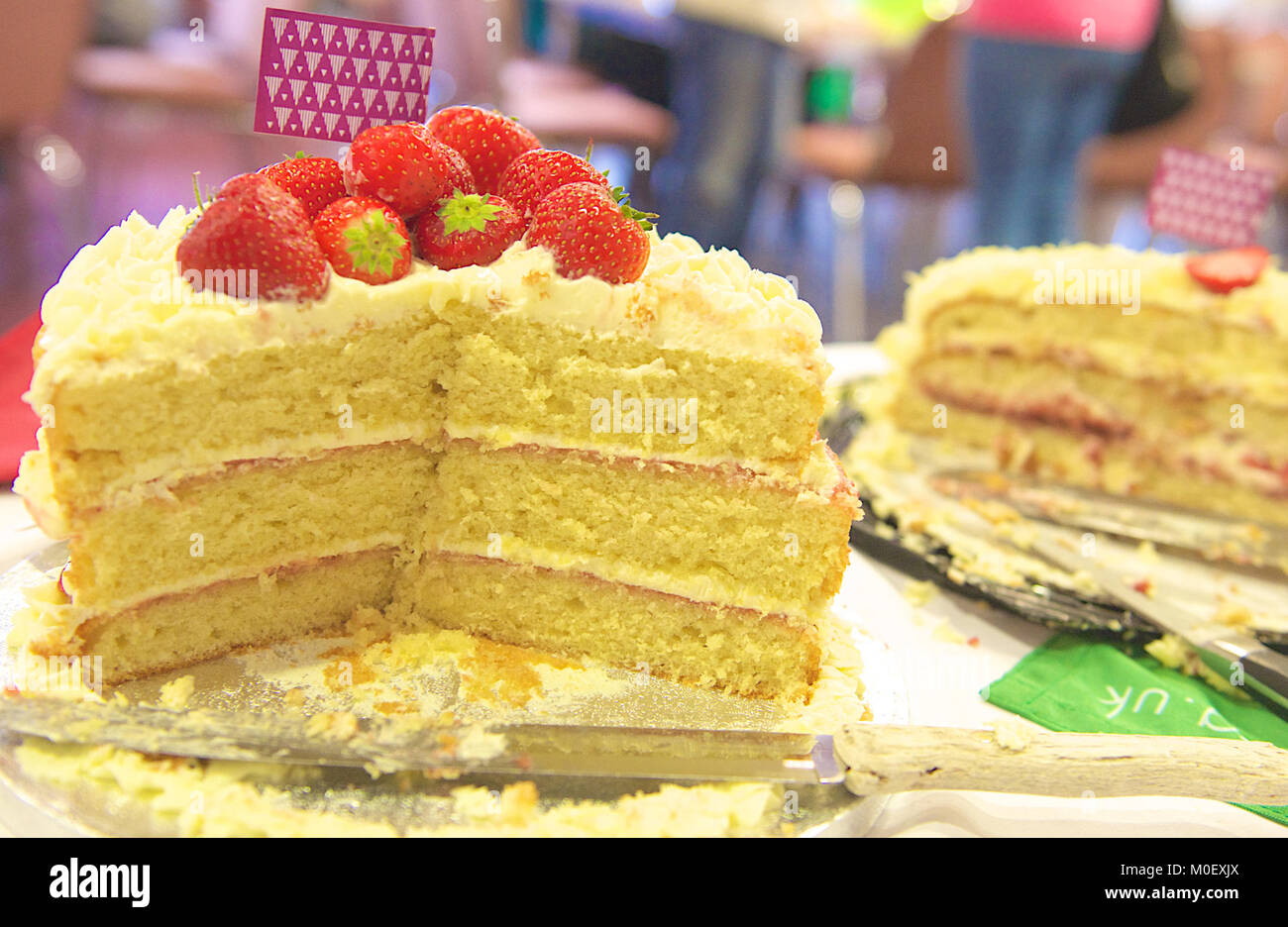 Close-up of a half eaten strawberry sponge cake at a cake fair Stock Photo