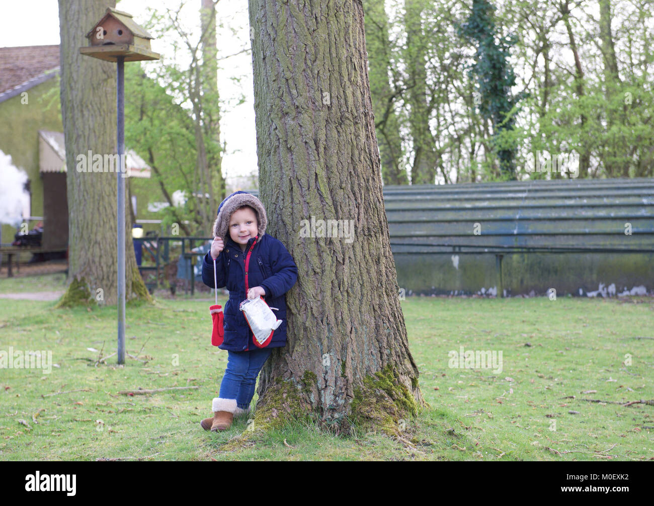 Girl standing in a public park holding a bag of crisps Stock Photo