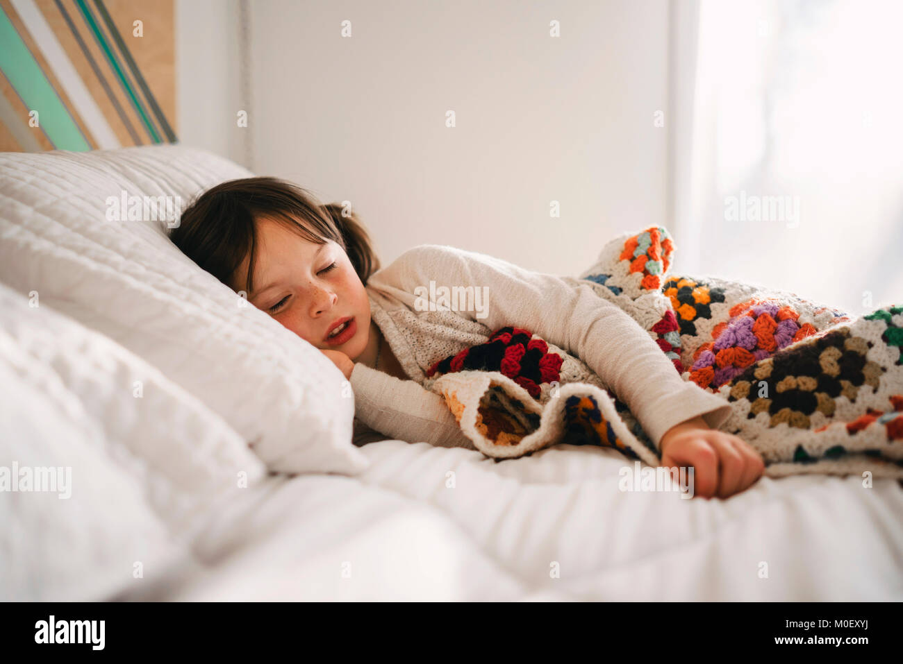 Girl lying in bed having an afternoon nap Stock Photo