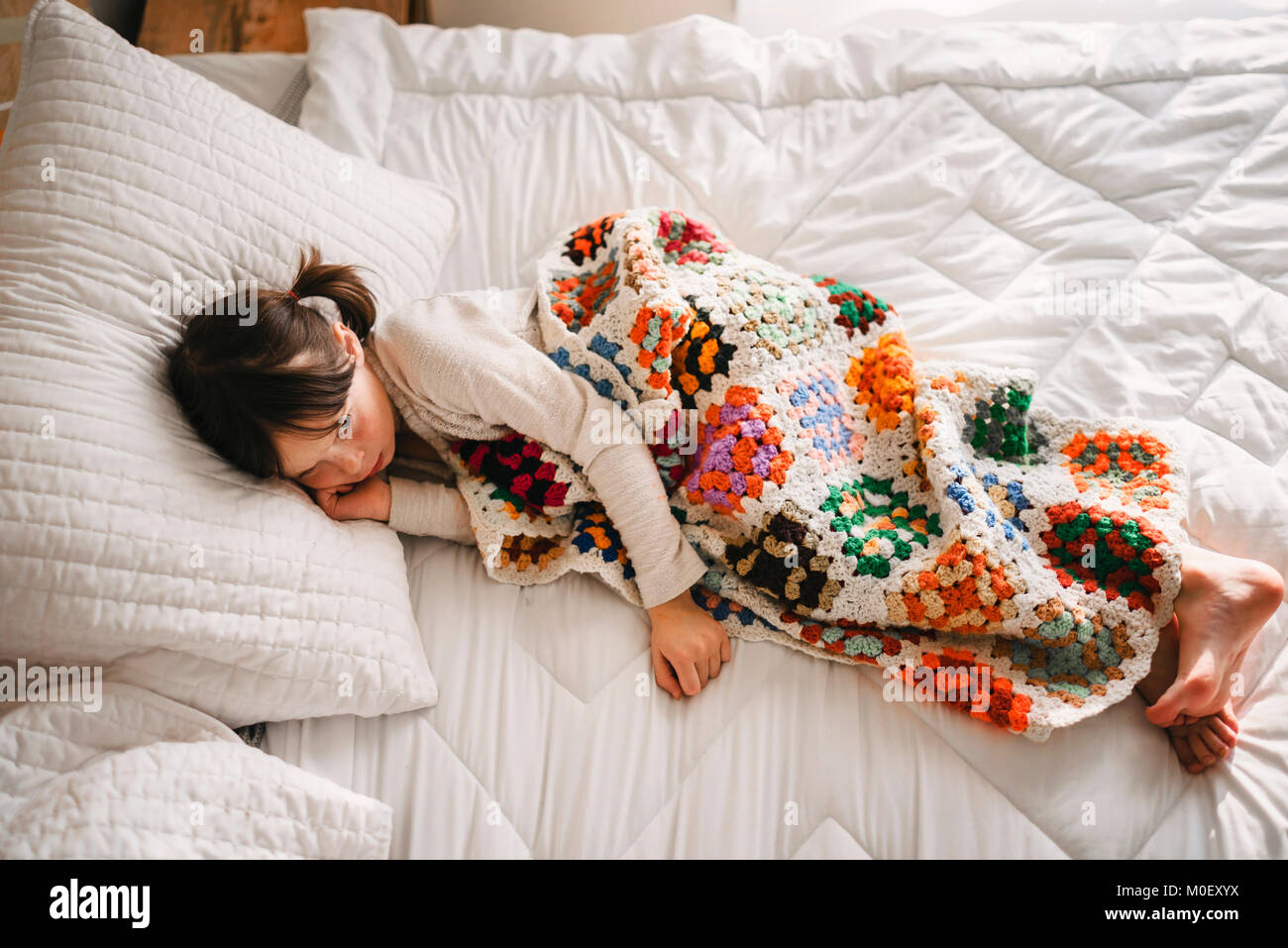 Girl lying in bed having a nap Stock Photo