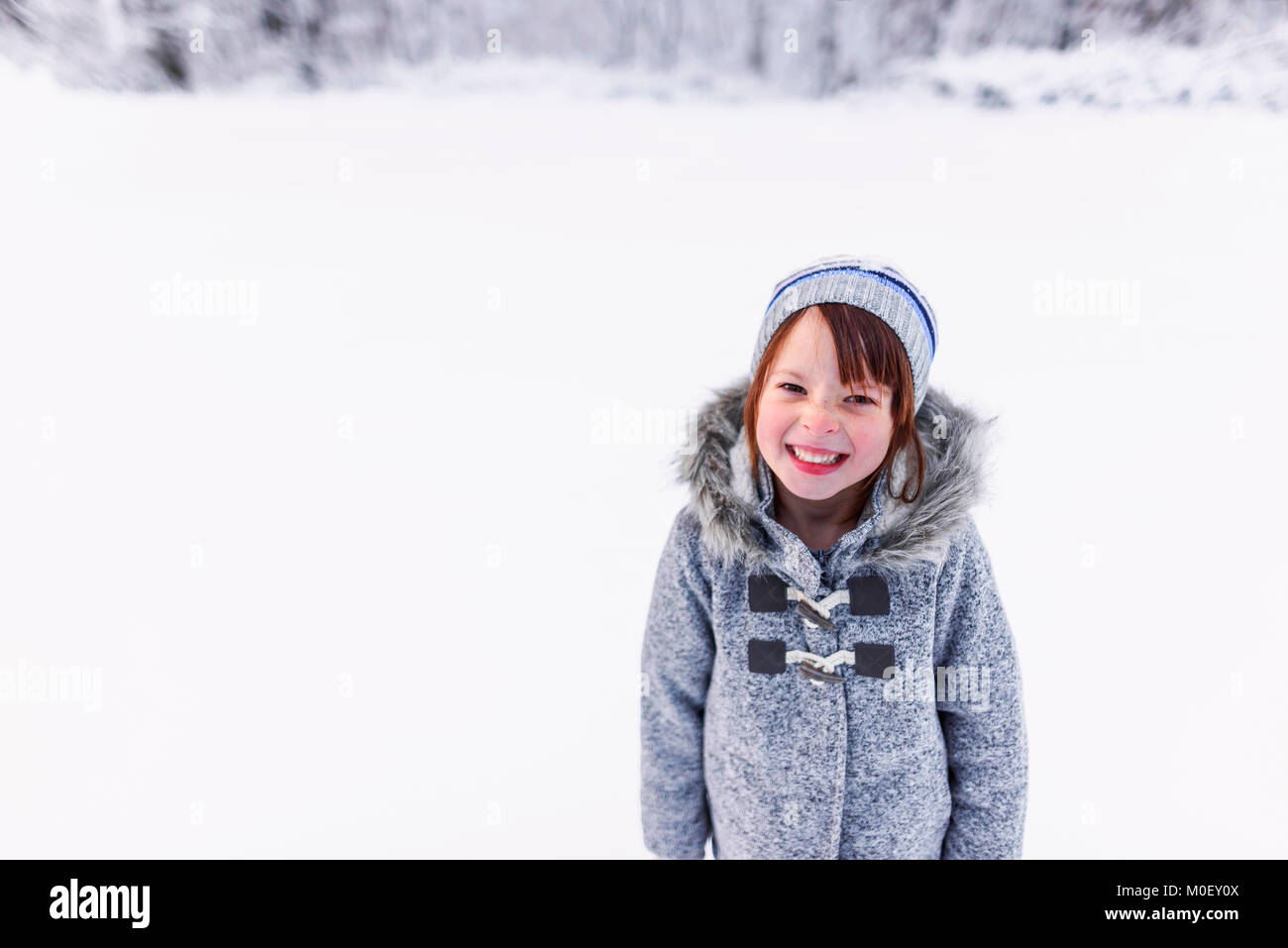 Portrait of a smiling girl standing in the snow Stock Photo - Alamy