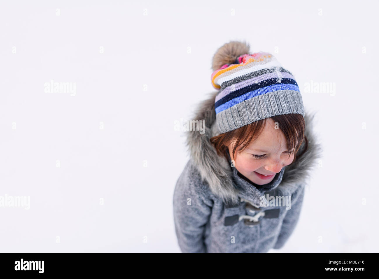 Portrait of a smiling girl standing in the snow Stock Photo