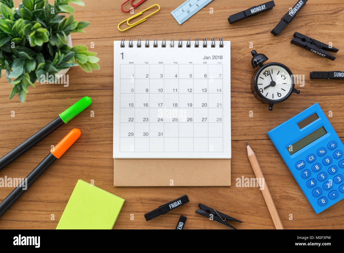 Calendar on wooden table with clock and calculator from top view Stock Photo