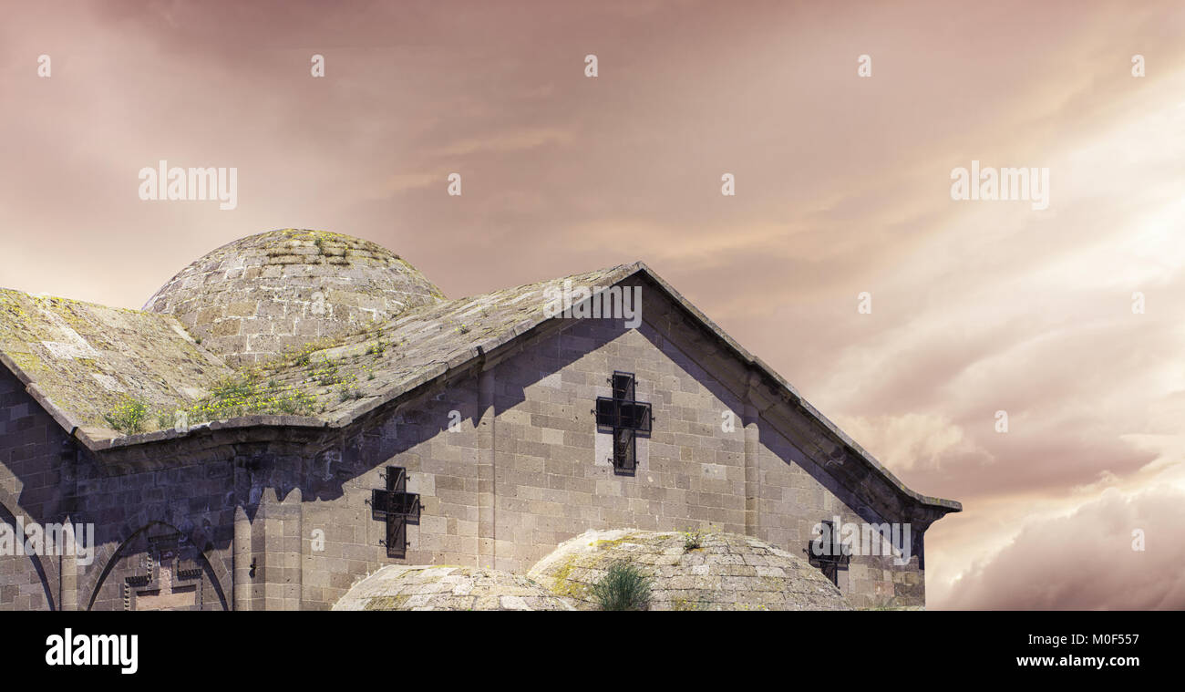 Rural old Stone church cross with dramatic sky Stock Photo