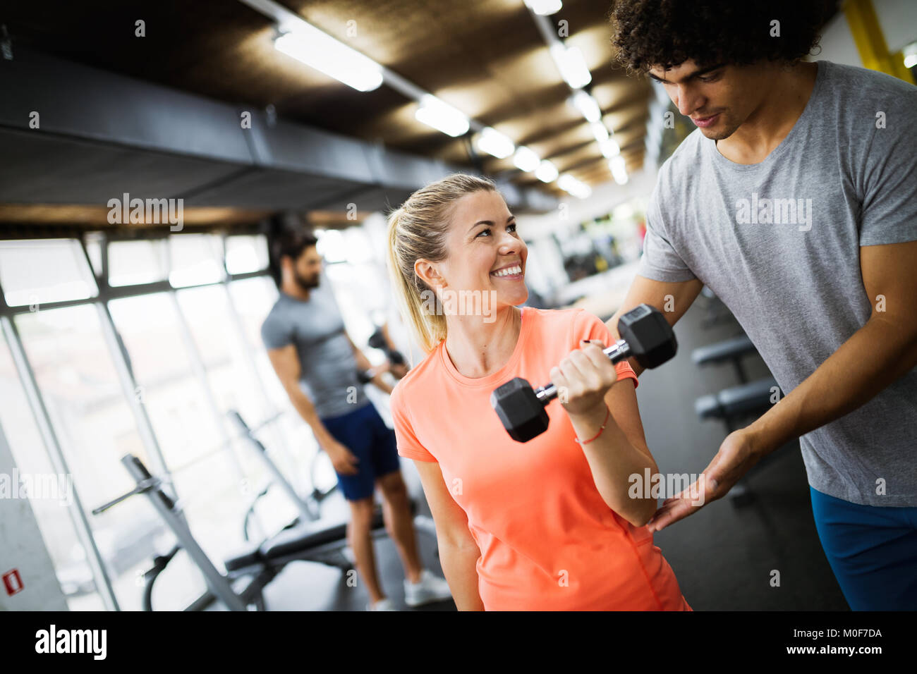 Young beautiful woman doing exercises with personal trainer Stock Photo