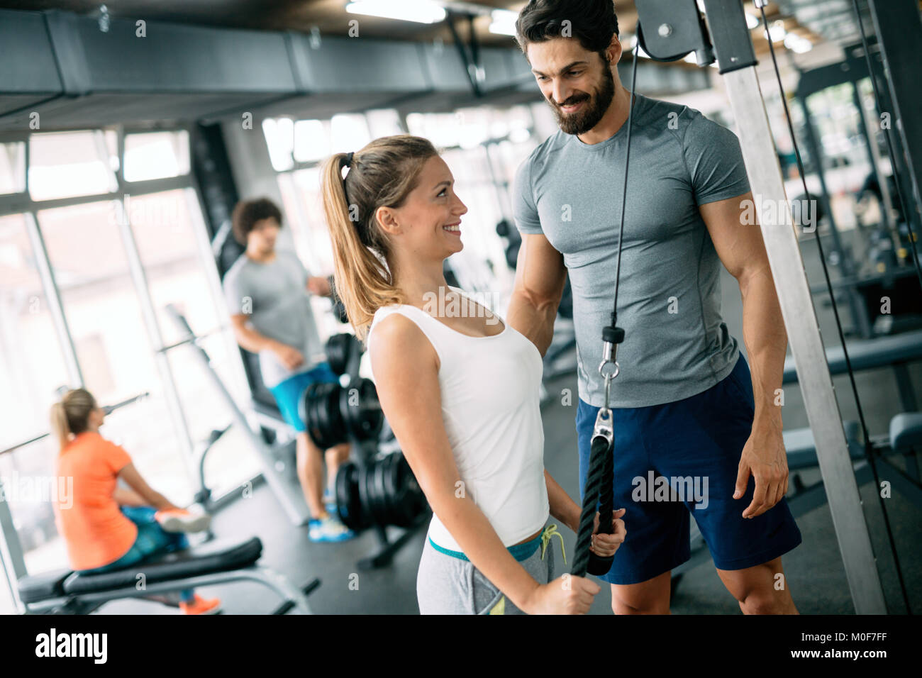 Young beautiful woman doing exercises with personal trainer Stock Photo