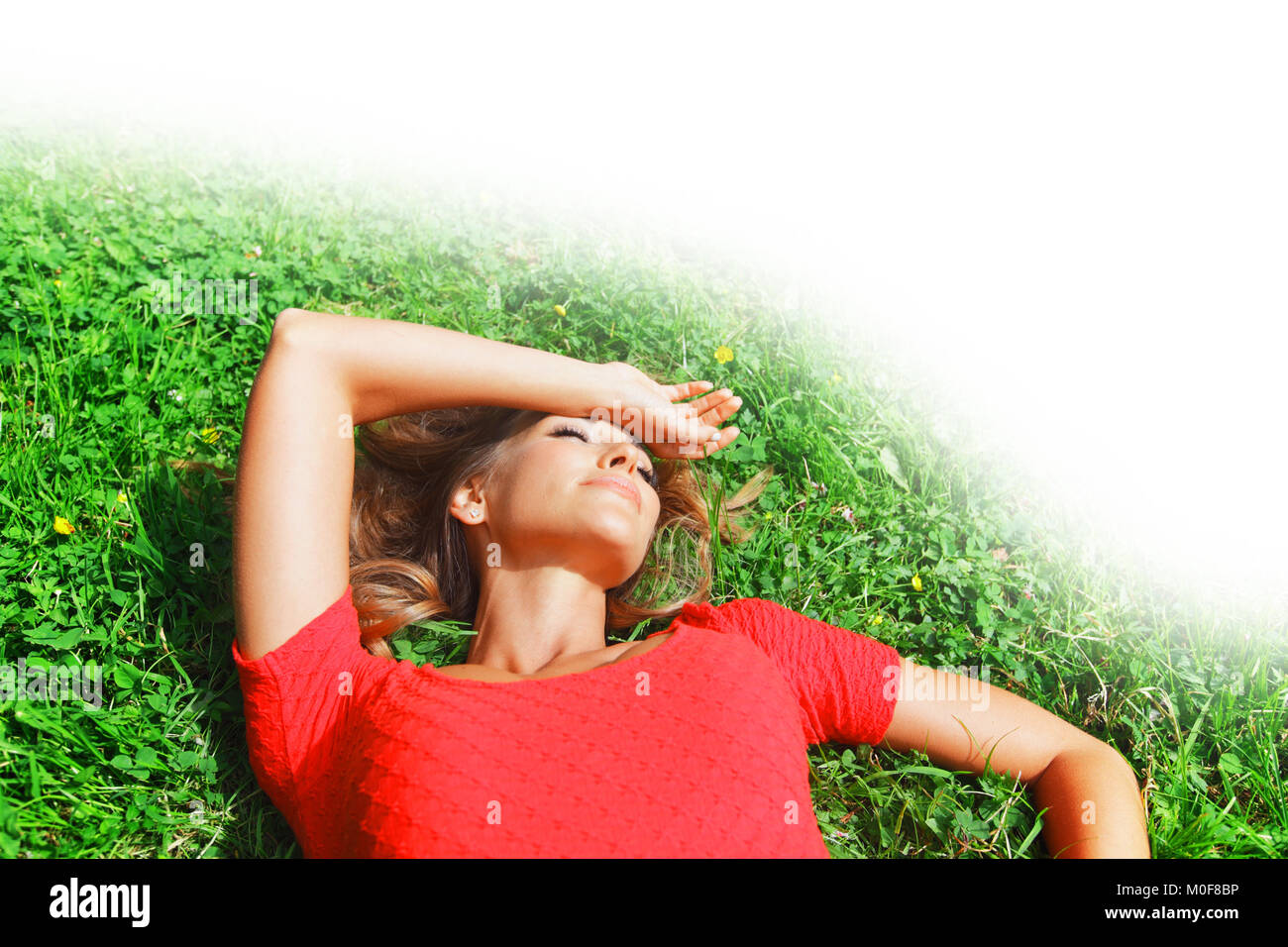 beautiful young woman in red dress lying on grass Stock Photo - Alamy