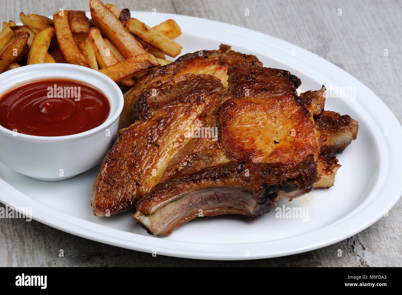 Fried pork loin steak with French fries and tomato sauce Stock Photo