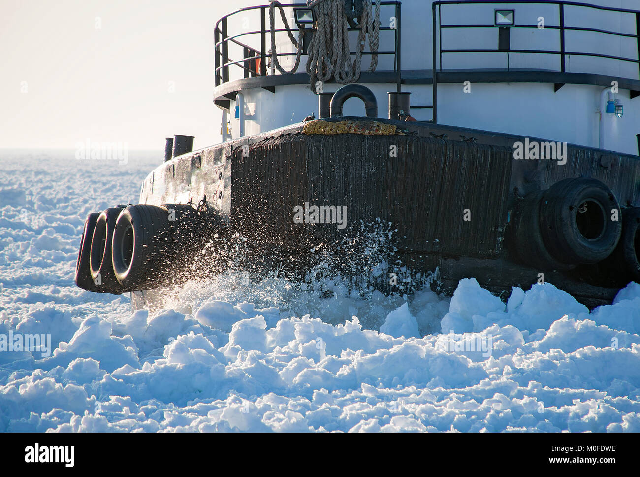 closeup of tugboat hull cutting through thick ice in Lake Michigan Stock Photo