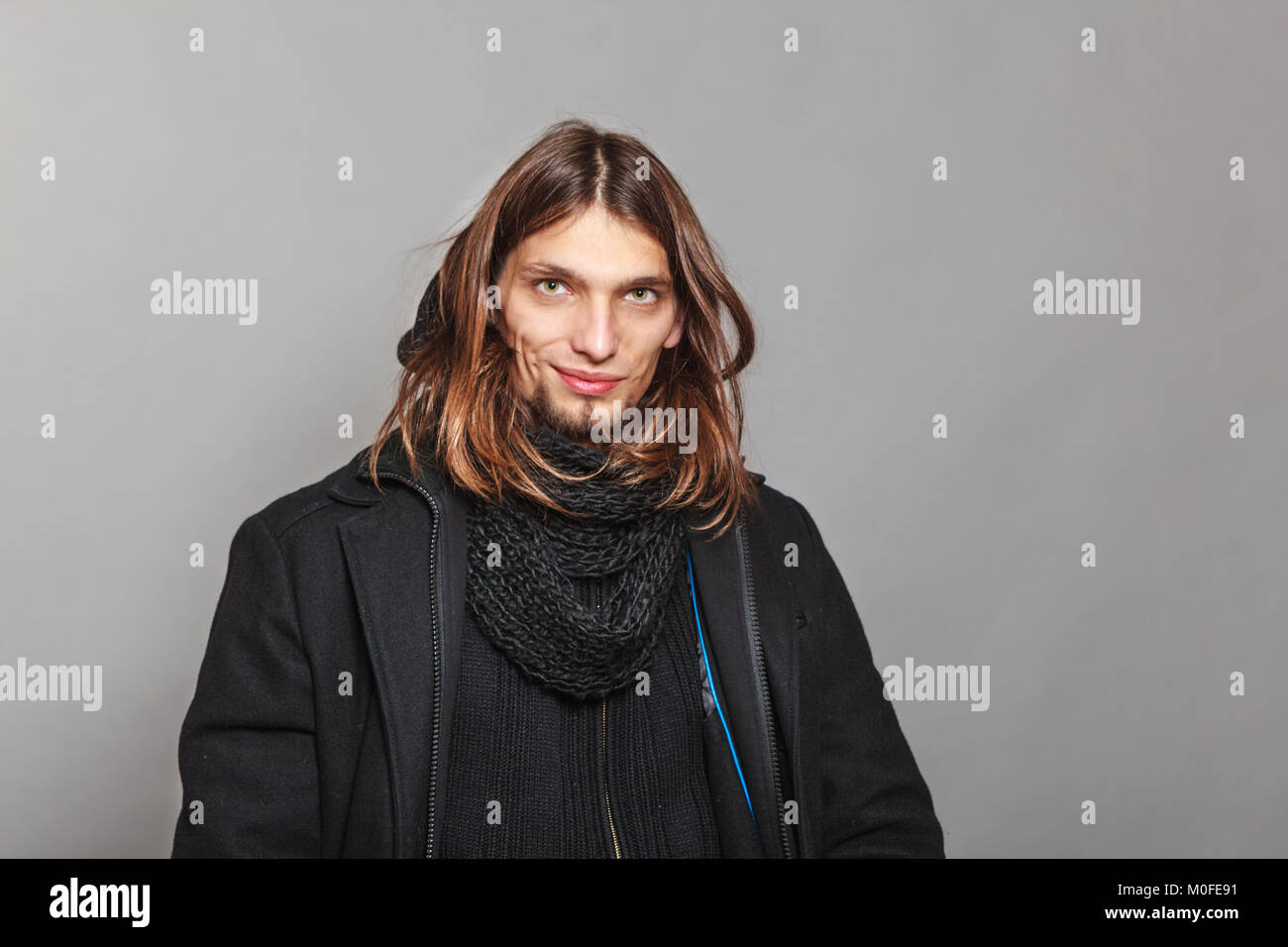 Portrait of handsome fashionable man wearing black coat and scarf ...
