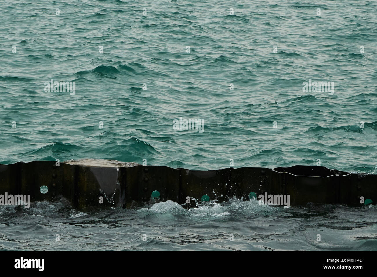 blue green water hitting breakwater along Chicago lakefront Stock Photo
