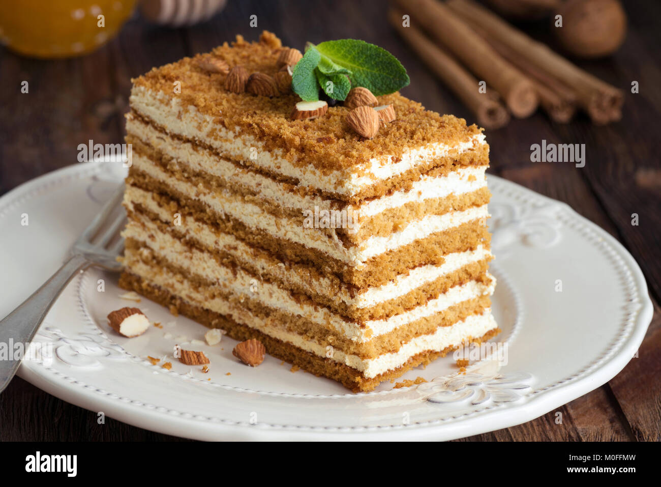Honey layer cake Medovik decorated with mint leaf and almonds. Russian honey cake. Closeup view