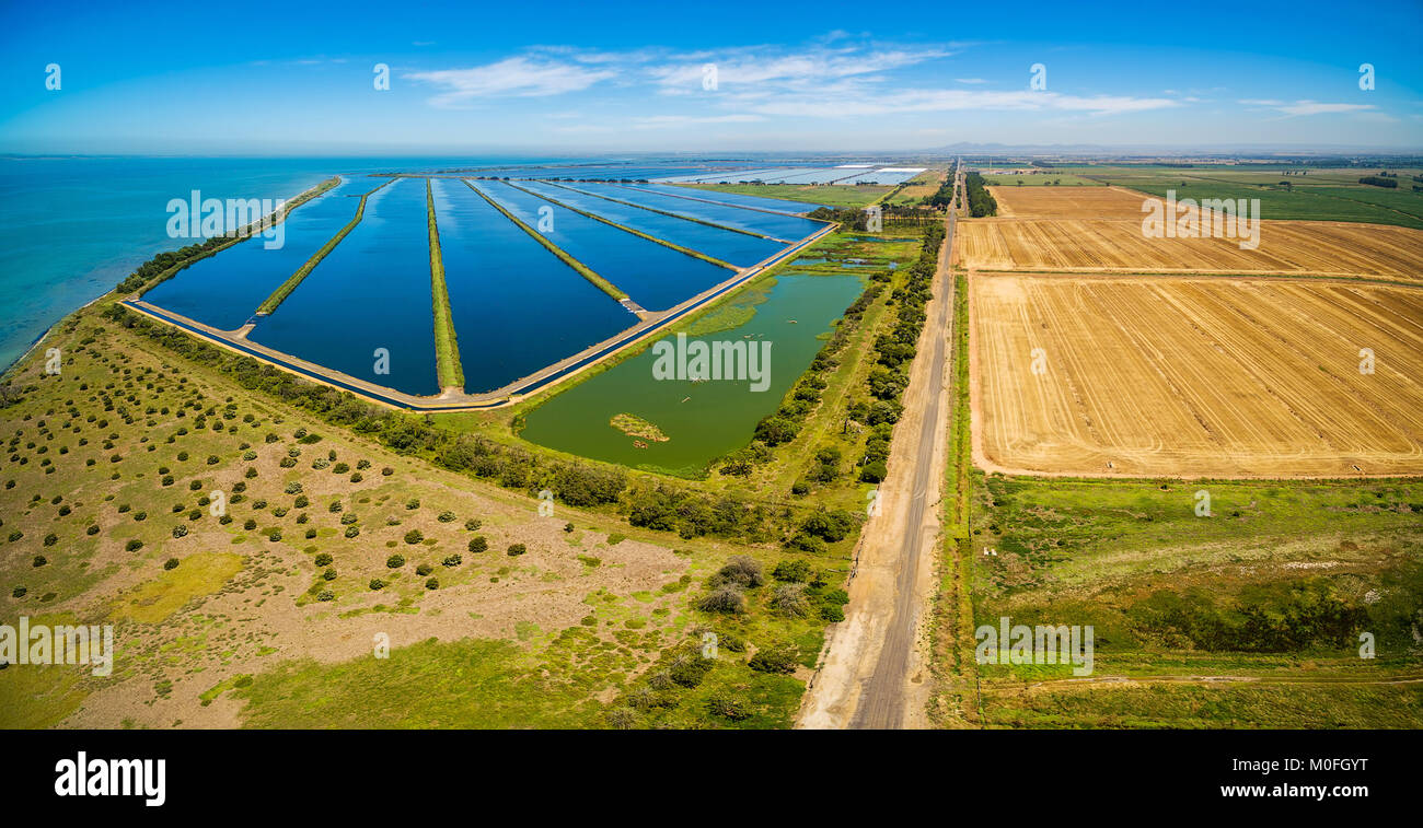 Aerial panoramic view of waste water treatment plant pools and plowed fields Stock Photo