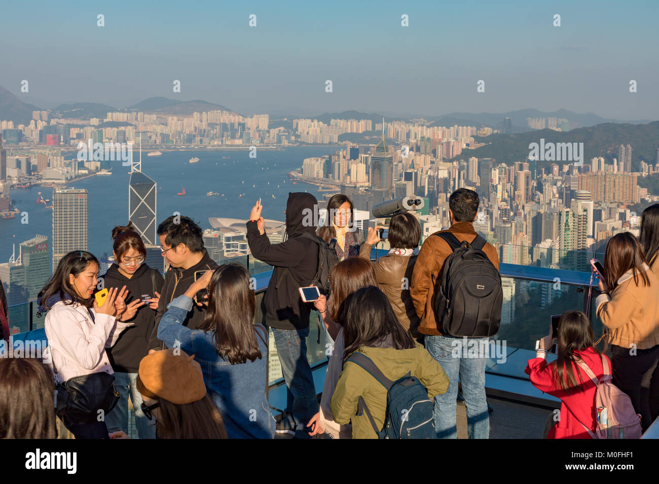 Hong Kong China Asia Jan 13, 2018 Visitors enjoying the evening view of the city and Hong Kong harbour from Victoria Peak Stock Photo