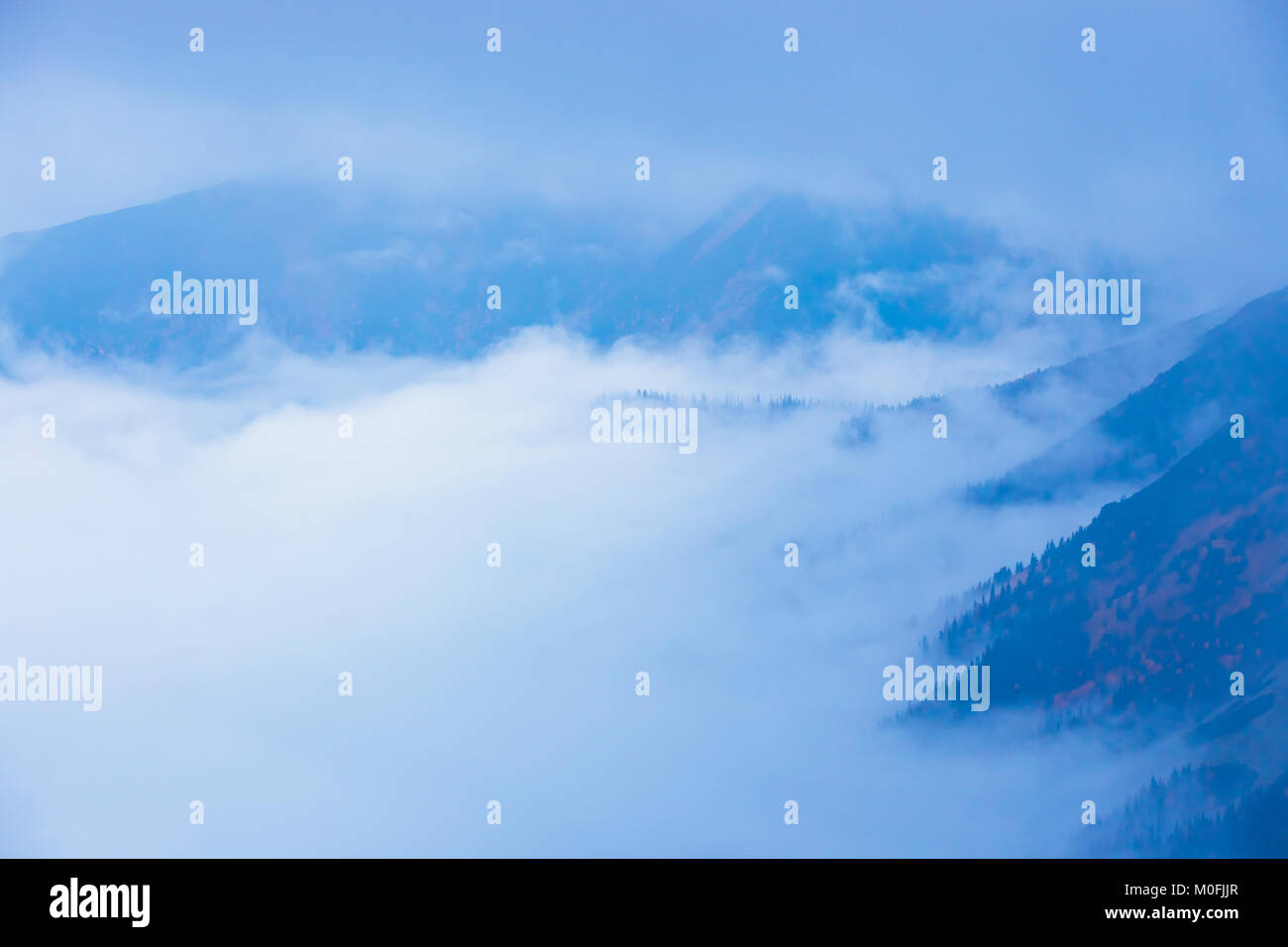 foggy mountain landscape with clouds above the peaks Stock Photo - Alamy
