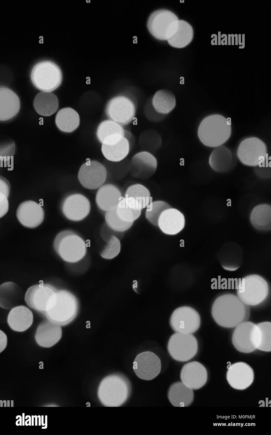 Bright circles of defocused color light on black background Stock Photo