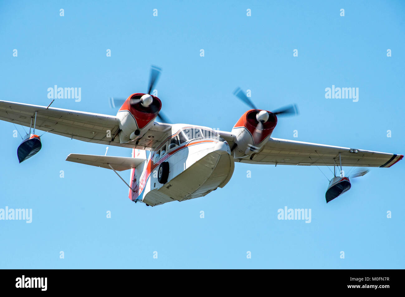 A Grumman Widgeon majestically cuts through the clear skies Stock Photo