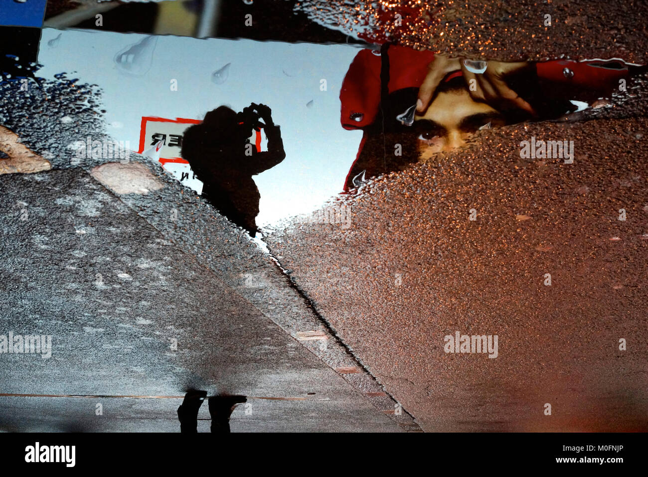 Woman takes a photo of the Piccadilly Circus advertising billboard, rainy London Stock Photo