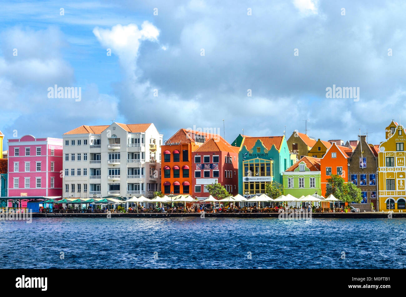 Brightly colored buildings lined up on the harbor in Curacao Stock