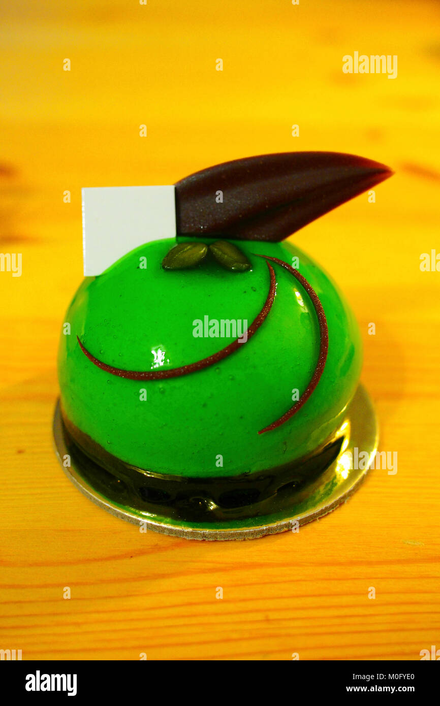 green colour mirror glaze mini mousse cake with chocolate topping Stock Photo