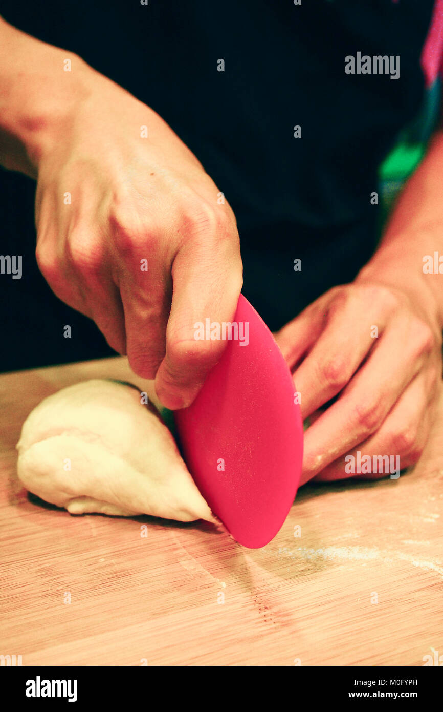 top view of a man cutting raw donut dough Stock Photo