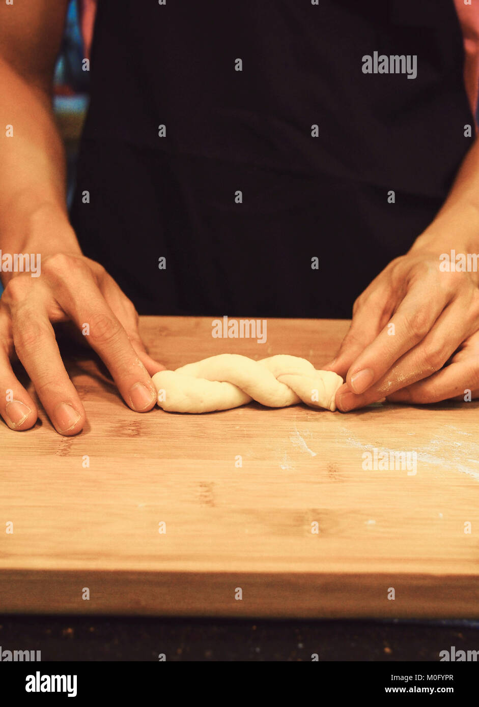 man kneading raw donut dough Stock Photo