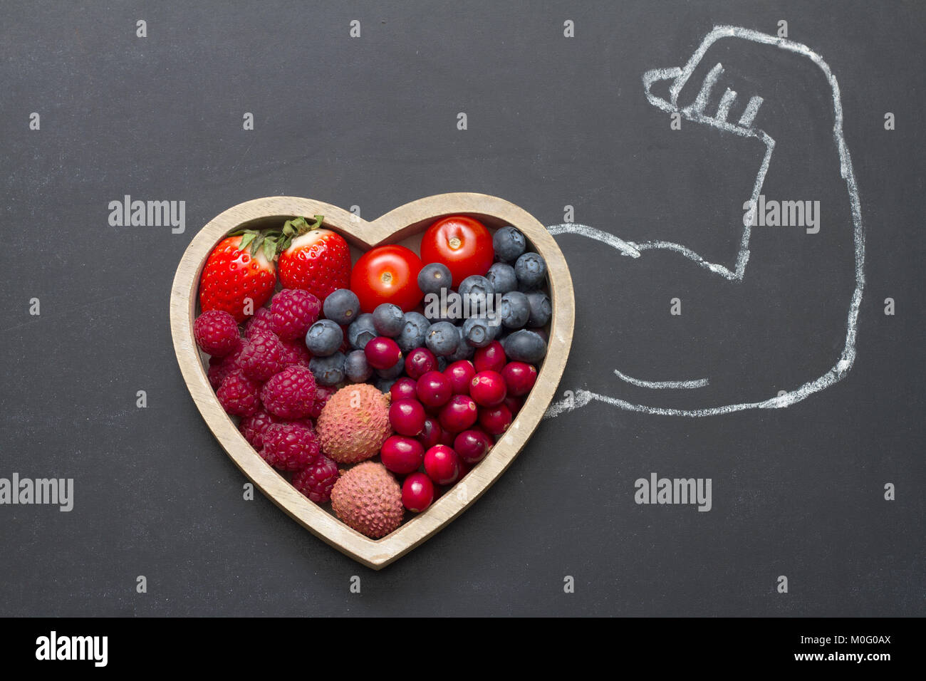 Health diet heart abstract concept with strongman hand on blackboard Stock Photo