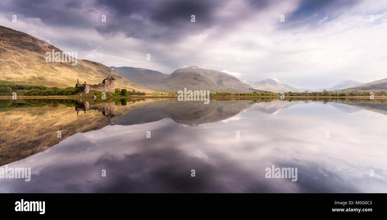 The ruins of Kilchurn Castle, home of the Clan Campbells of Glenorchy, and the mountains of Argyll are reflected in the calm waters of Loch Awe in the Stock Photo