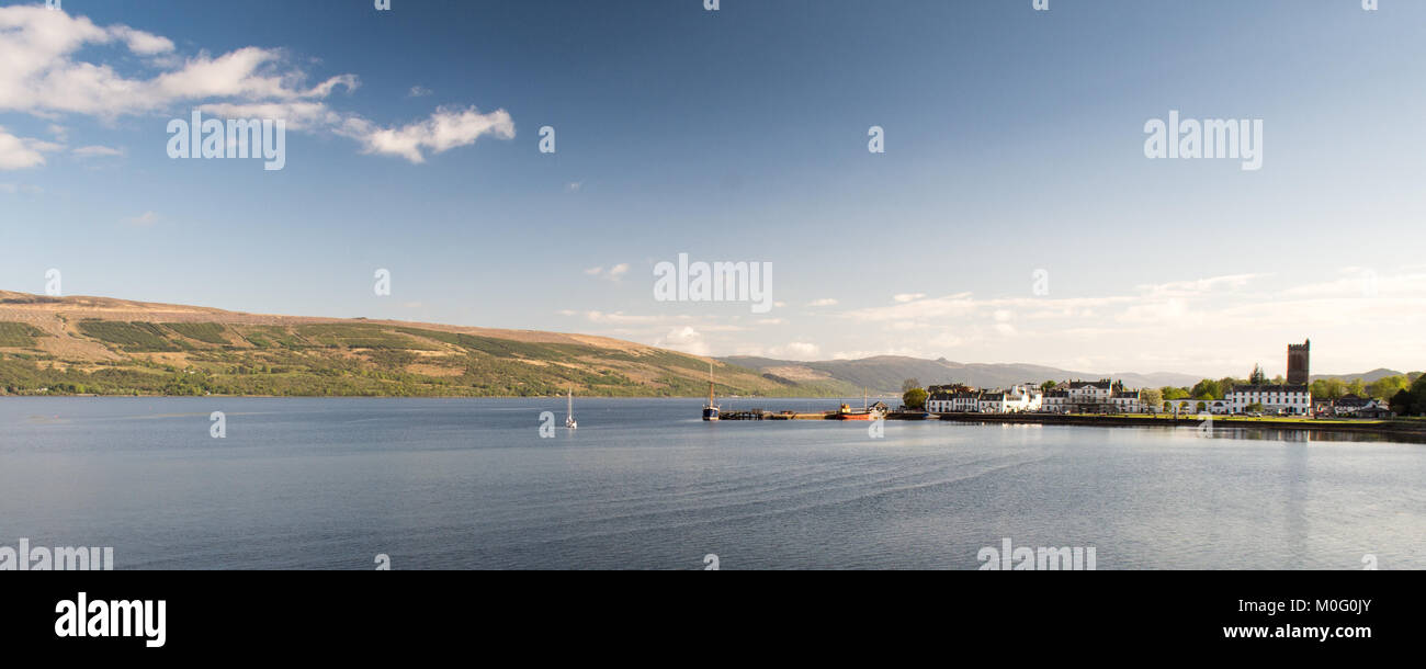 Whitewashed waterfront houses over Inveraray on the shores of Loch Fyne sea loch, with sailing boats moored at the pier, in Argyll in the south west H Stock Photo