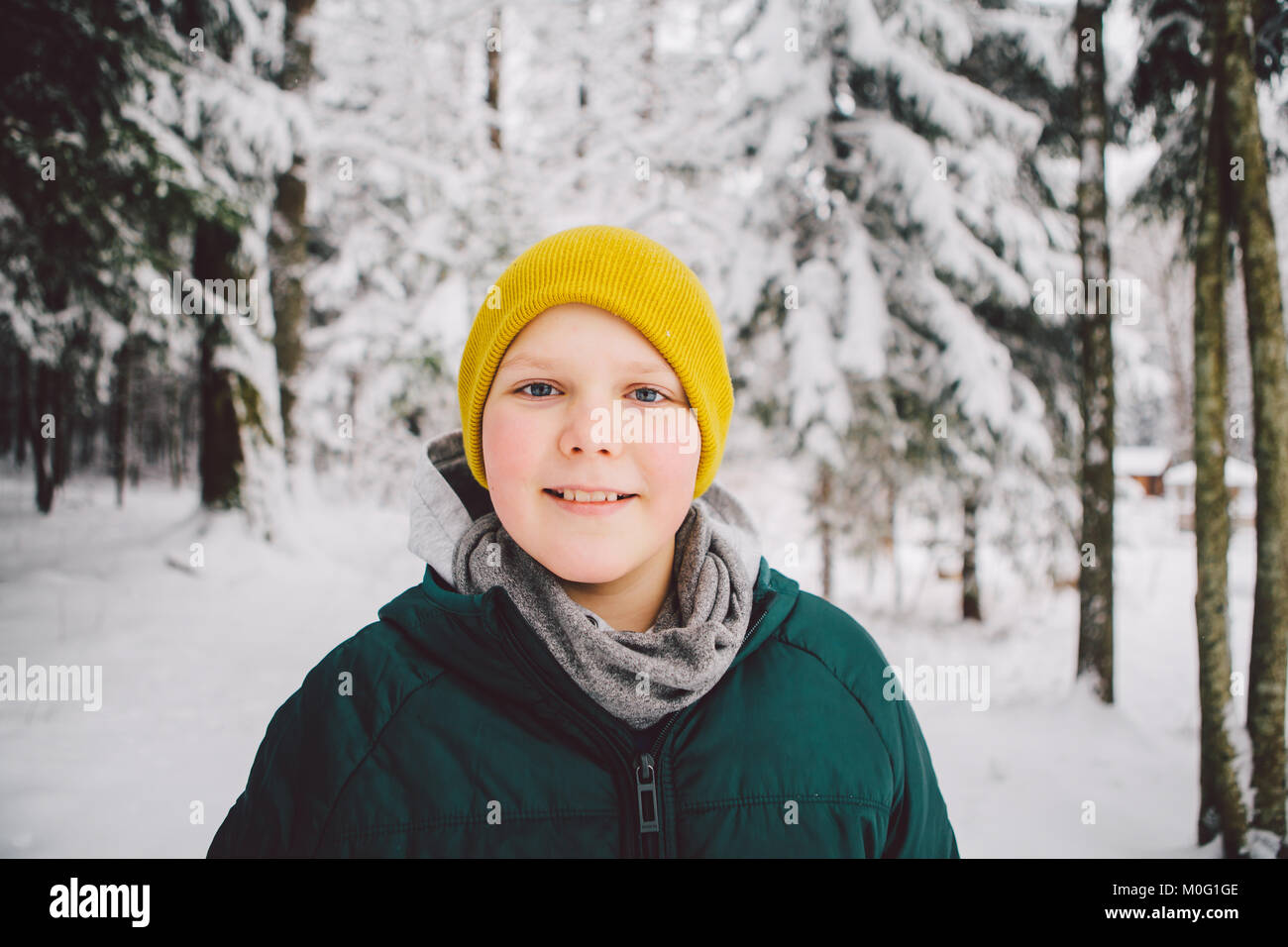 Smiling boys standing in the forest in the snow looking at camera. Stock Photo