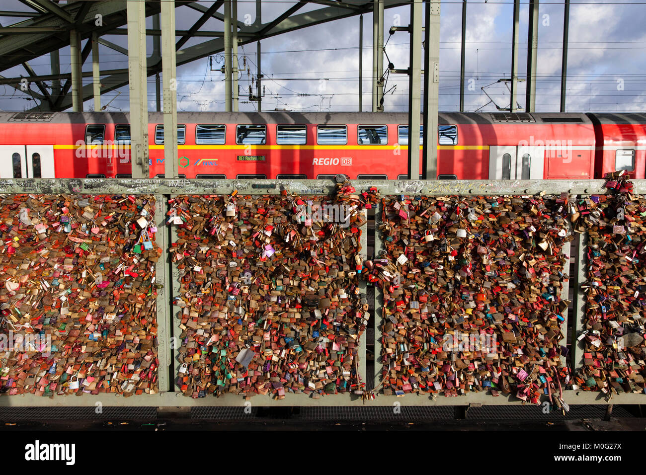 Europe, Germany, Cologne, padlocks on fence of footpath of the Hohenzollern railway bridge. Young couples seal their love with engraved padlocks and t Stock Photo