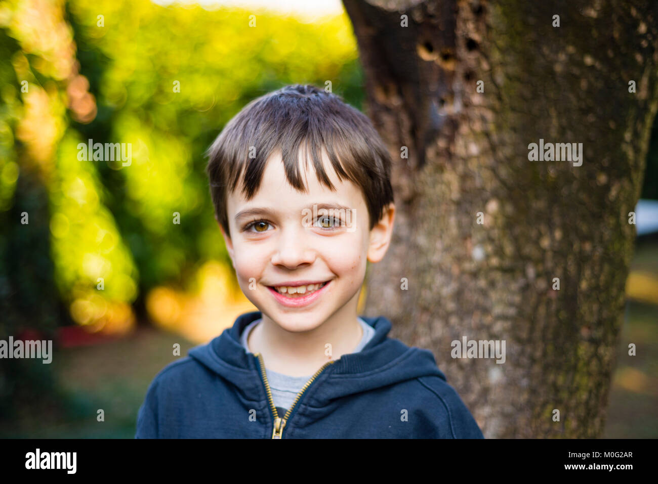portrait of 7 year old boy outdoor in the garden in winter Stock Photo