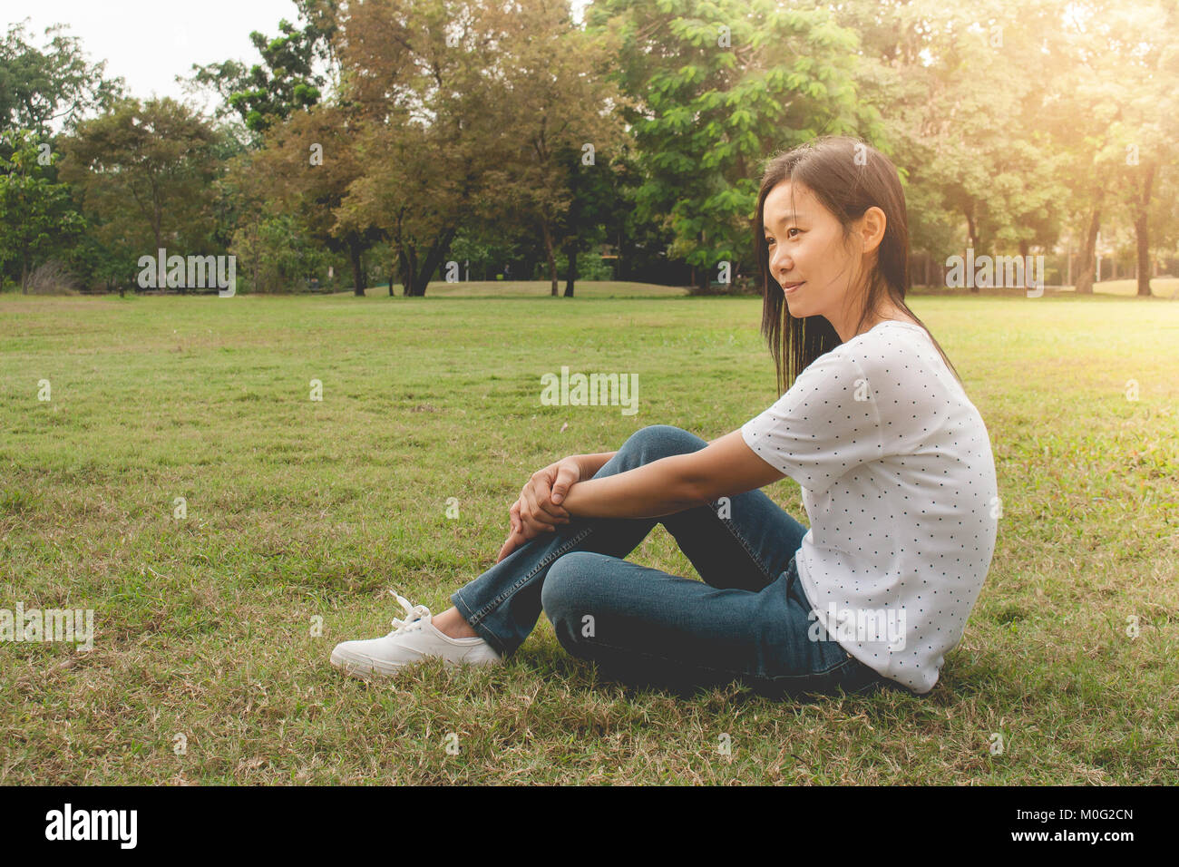 Woman relaxing and lies on green grass in the park in vintage style ...