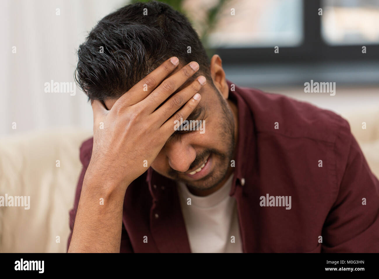 close up of man suffering from head ache at home Stock Photo