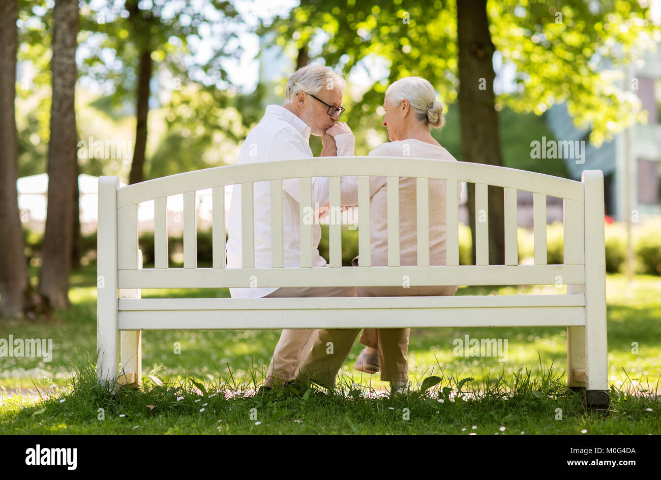 happy senior couple sitting on bench at park Stock Photo - Alamy