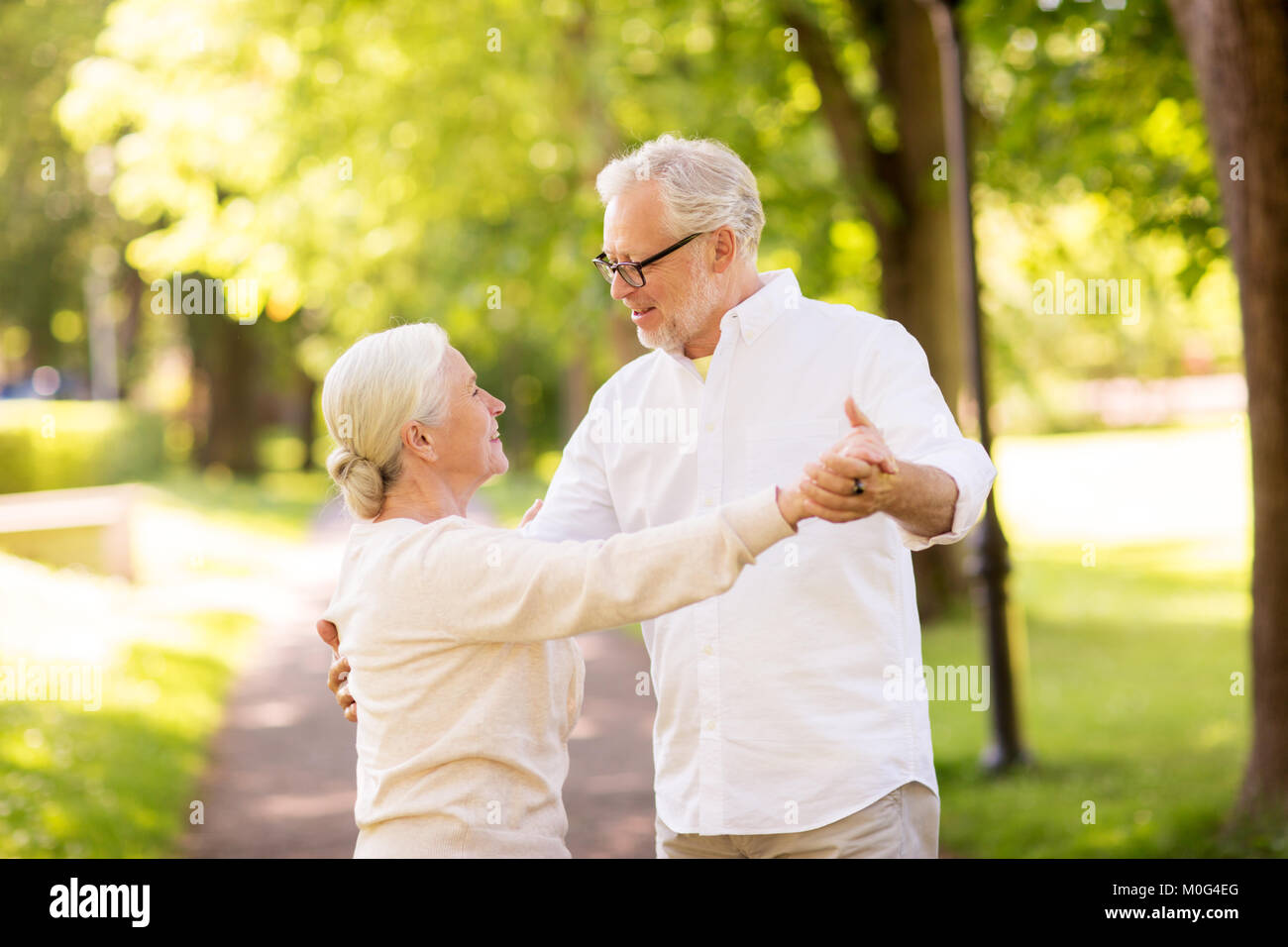 happy senior couple dancing at summer park Stock Photo - Alamy