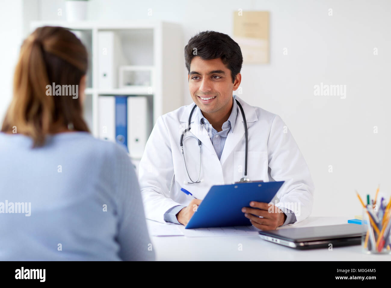 doctor with clipboard and patient at hospital Stock Photo - Alamy