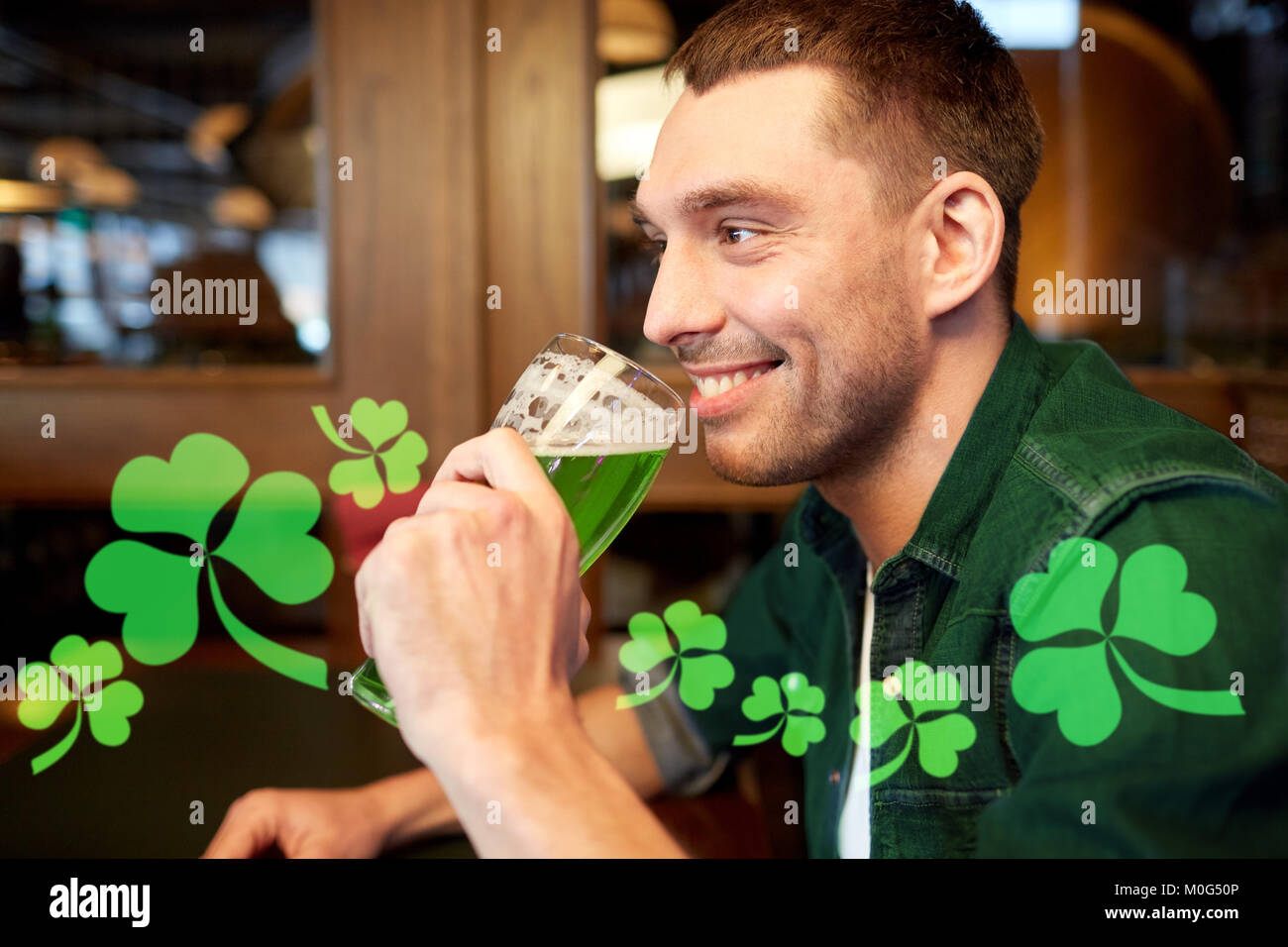close up of man drinking green beer at bar or pub Stock Photo