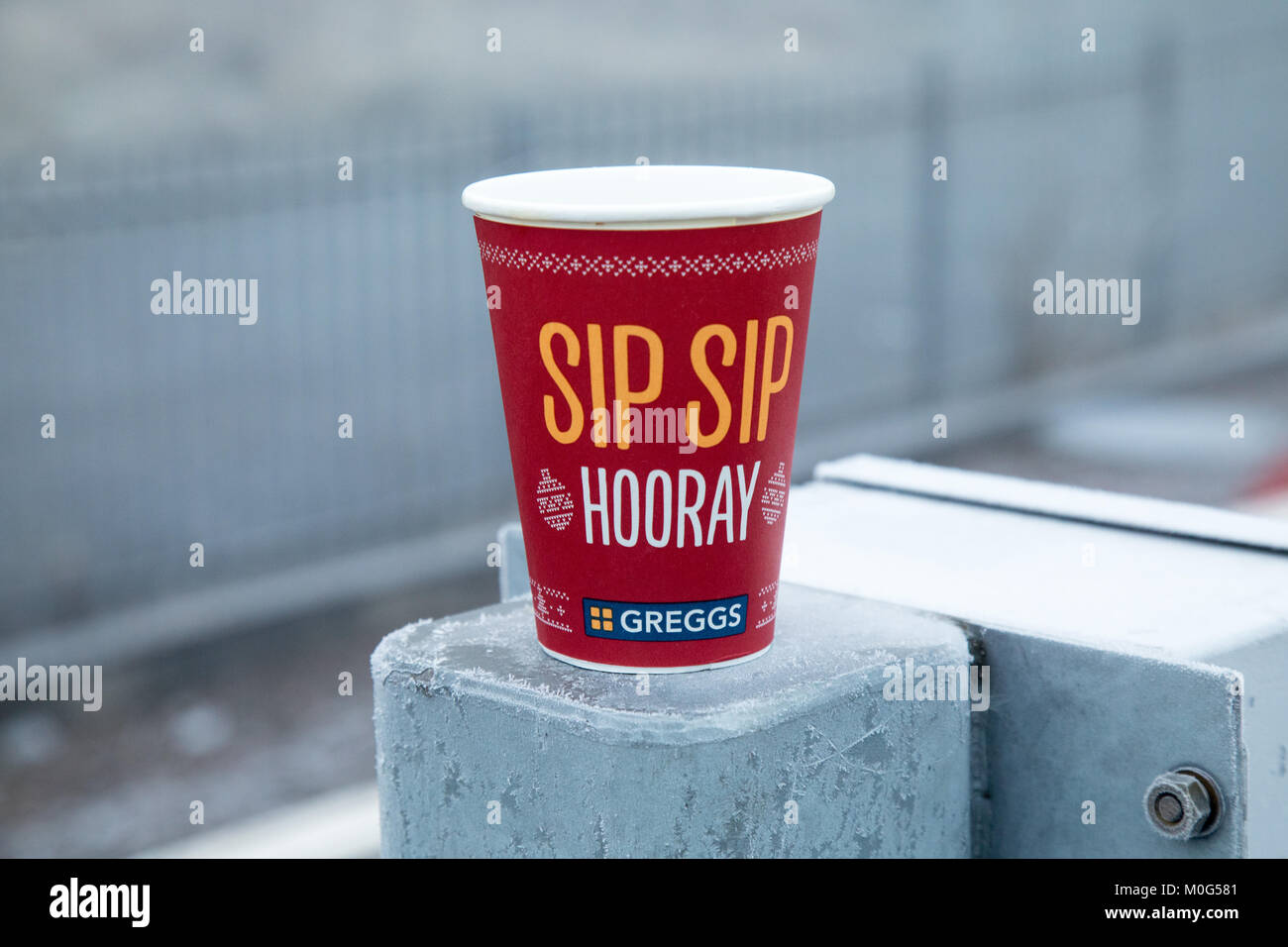 A Greggs Christmas takeaway cup sitting on a pillar at Anniesland train station in Glasgow. The cup logo is Sip Sip Hooray. Stock Photo