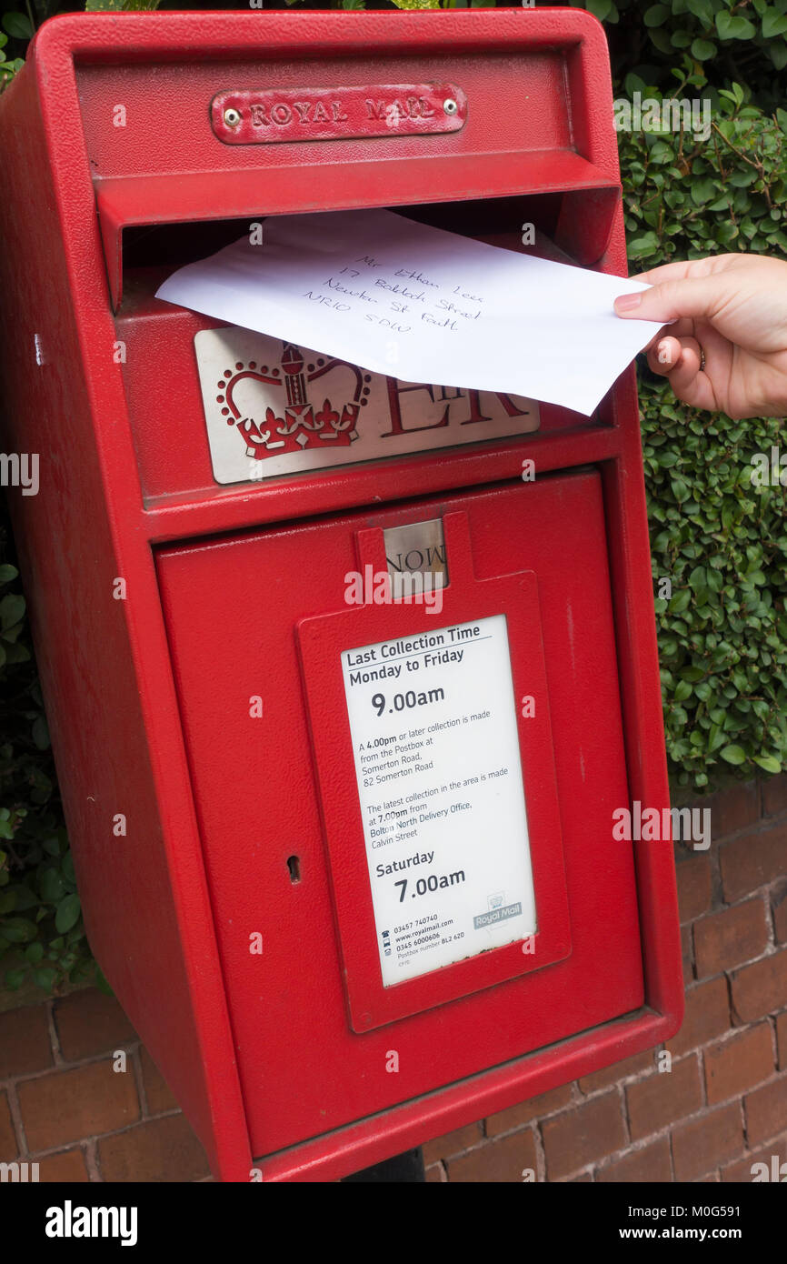 Letter being posted in a red Royal Mail post box Stock Photo Alamy