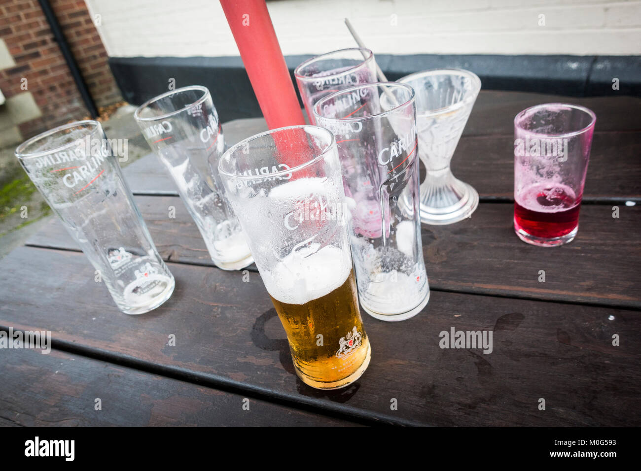 Empty and part empty glasses on a table outside a pub Stock Photo