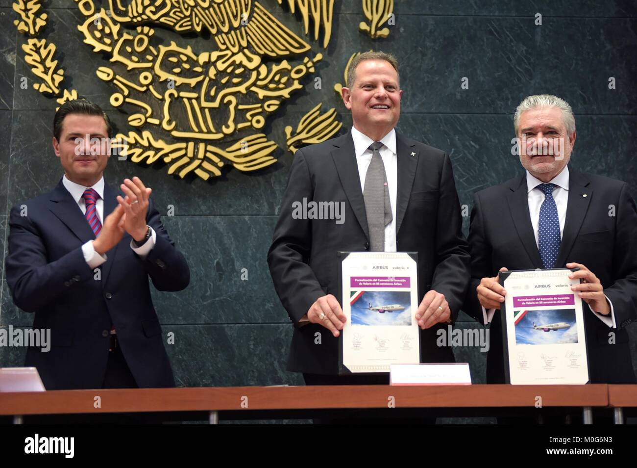 Mexican President Enrique Pena Nieto, left, applauds Volaris CEO  Enrique Beltranena, center, and Airbus President for Latin America Rafael Alonso during an announcement at the National Palace January 17, 2018 in Mexico City, Mexico. The Mexican discount carrier Volaris announced the purchase of 80 Airbus aircraft worth $9.3 billion dollars. Stock Photo