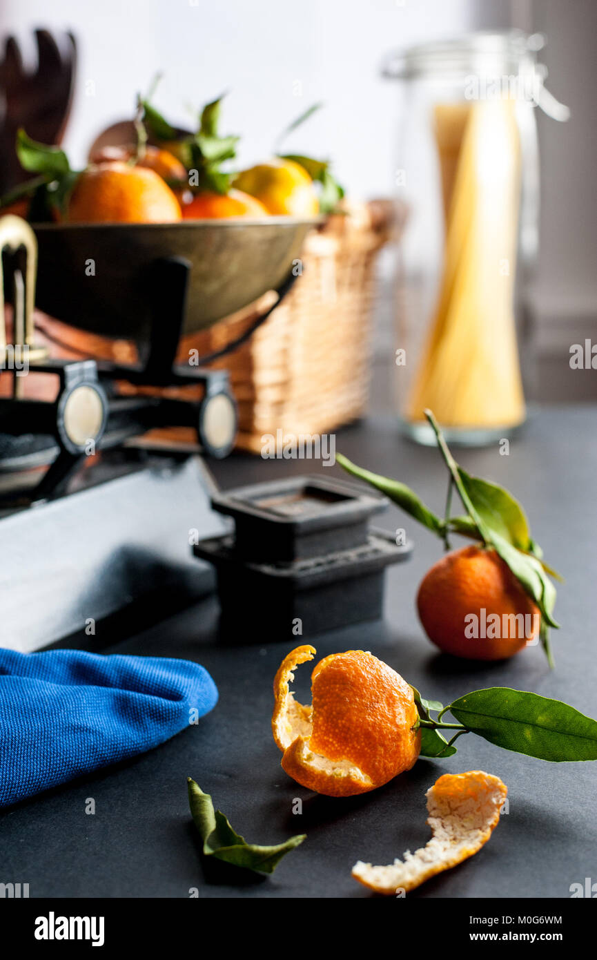 Fresh whole clementines with green leaves in vintage scale and one
