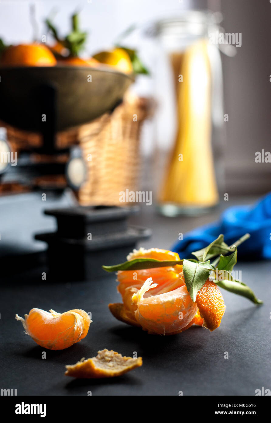 Fresh whole clementines with green leaves in vintage scale and one