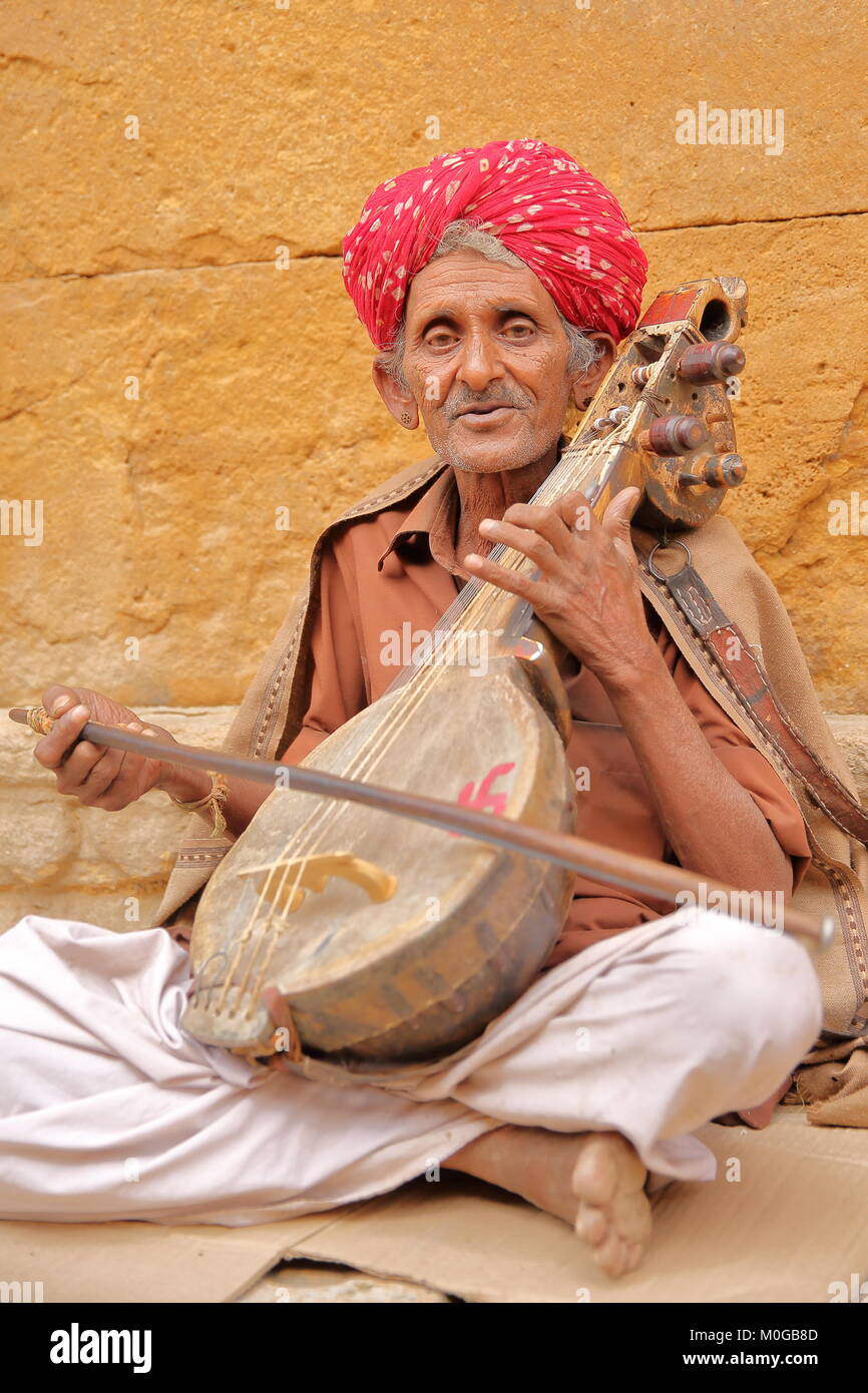 JAISALMER, RAJASTHAN, INDIA - DECEMBER 20, 2017: Portrait of a musician with a nice and colorful turban playing a traditional instrument Stock Photo