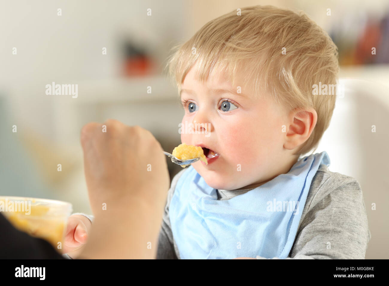 Close up portrait of a mother hand feeding a baby at home Stock Photo