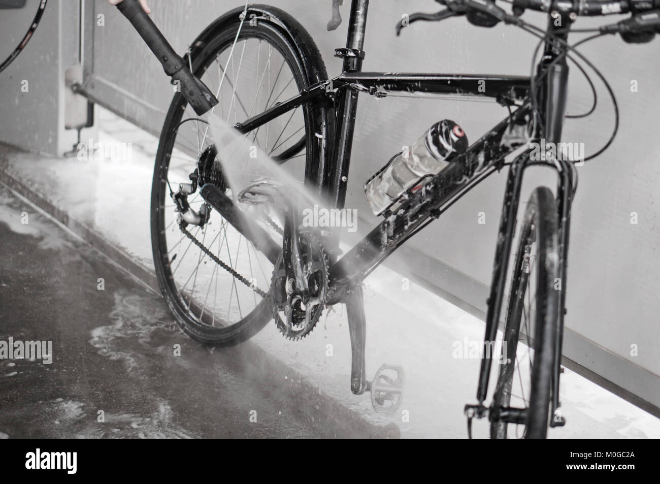 man washing the bike with a strong jet of water, washing the bike after