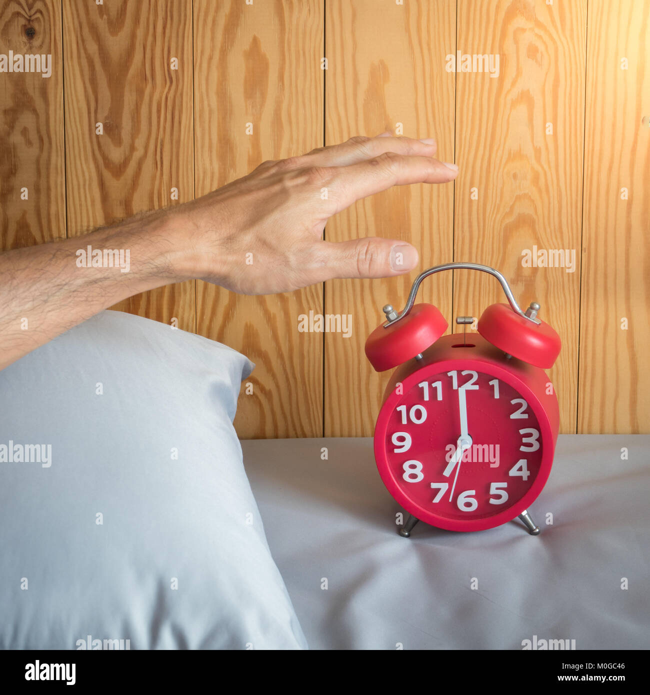 Hand of a man turn off alarm clock at morning Stock Photo Alamy