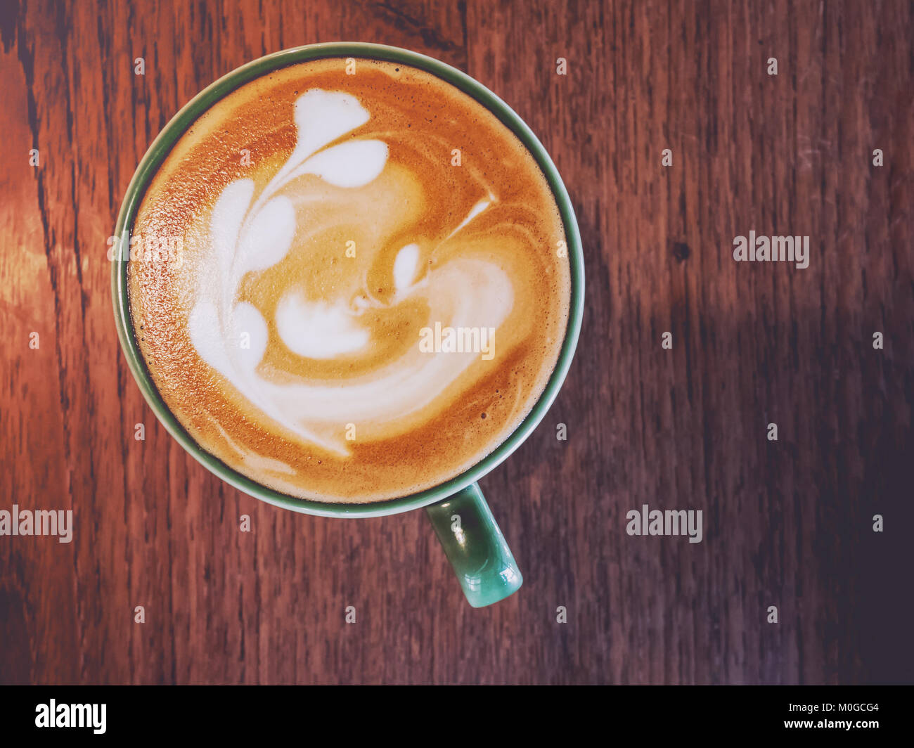 Hot coffee with latte art on table in coffee shop for background or cafe menu design. Stock Photo