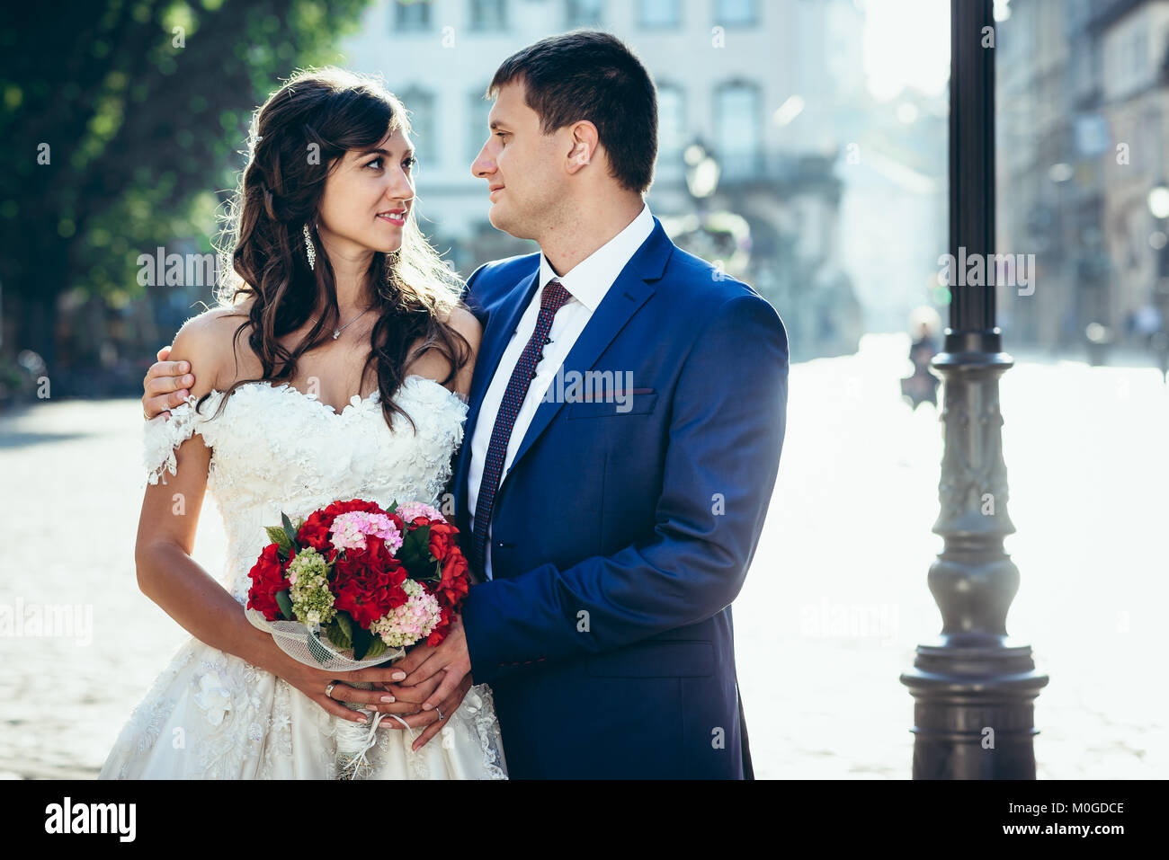 Sensitive portrait of the happy newlywed couple hugging and looking in ...